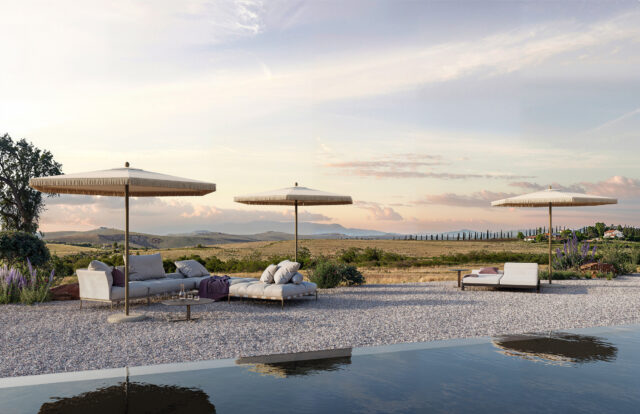 Gepolsterte Sofas und Sonnenschirme auf einer Kiesterrasse an einem spiegelnden Pool schaffen einen einladenden Lounge-Bereich im Freien. Hier wird fachmännischer Garten- und Landschaftsbau inmitten sanfter Hügel bei Sonnenuntergang in Luxemburg und Deutschland präsentiert.