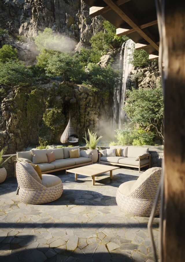 Eine gemütliche Außenterrasse mit gepolsterten Gartenmöbel-Sofas, runden Stühlen und einem hölzernen Couchtisch auf Steinboden, umgeben von üppigem Grün und einem Wasserfall, der sich über die felsigen Klippen ergießt, ganz im Stil von Gardendesign.
